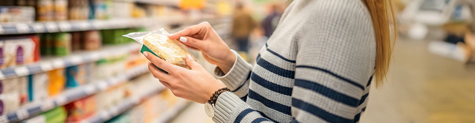 Eine Kundin schaut sich eine Packung Bio-Kekse bei Fairmann's Tochter an.